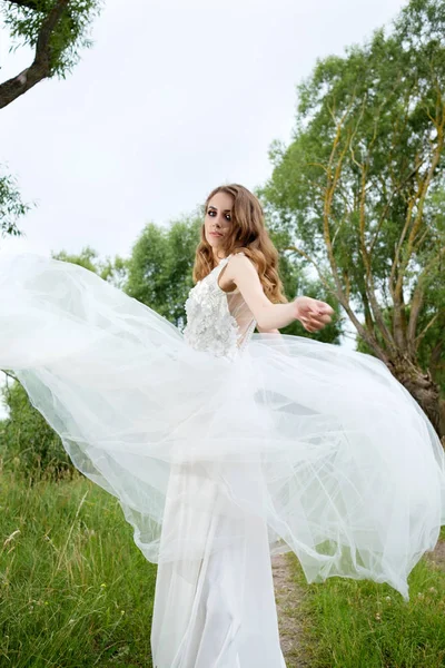 young pretty bride in white wedding dress spin around