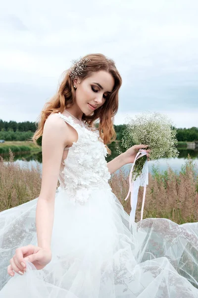 Joven novia bonita en vestido de novia blanco al aire libre, maquillaje y —  Fotos de Stock