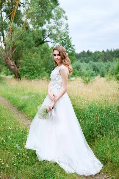 Joven novia bonita en vestido de novia blanco al aire libre, maquillaje y —  Fotos de Stock