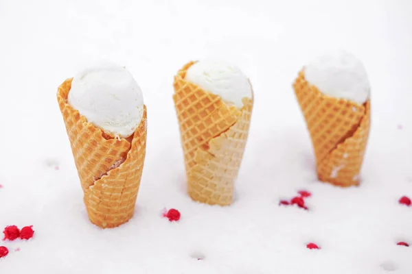 Ice cream in waffle cone with red berries of currant in snow — Stock Photo, Image