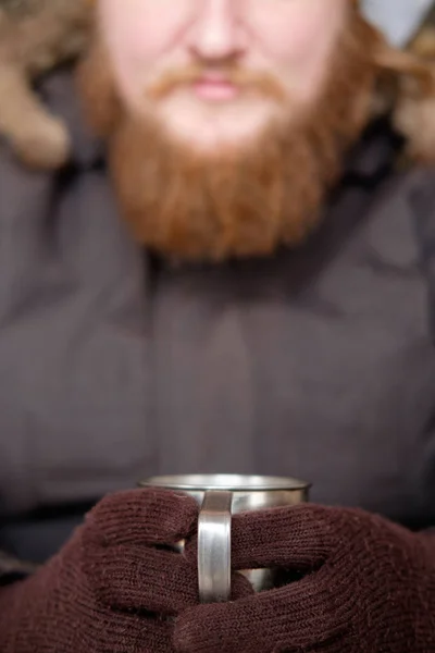 Pelirroja hombre barbudo en chaqueta polar sosteniendo taza de café caliente o — Foto de Stock