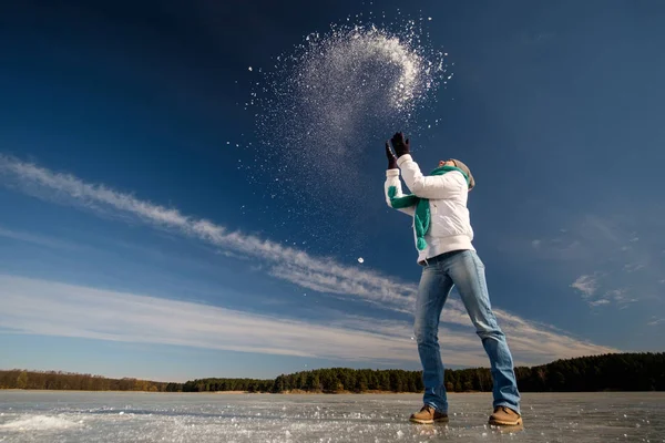 Menina iwhite jacke e cachecol azul se divertindo jogando pedaços de — Fotografia de Stock