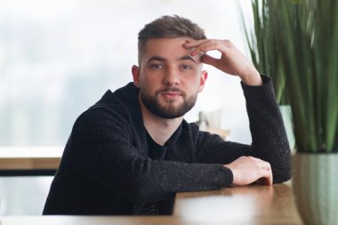 Genç ciddi portresi oturan yakışıklı beyaz adam sakallı