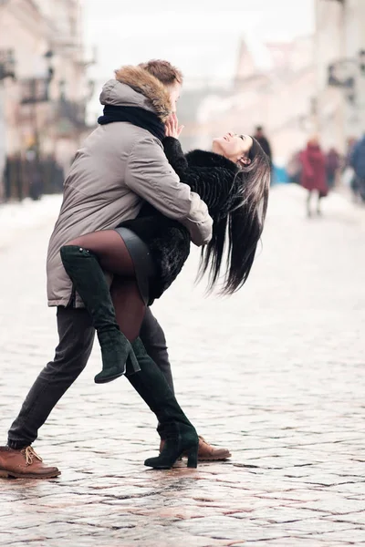 Jovem casal feliz abraçar uns aos outros enquanto caminha na rua de — Fotografia de Stock