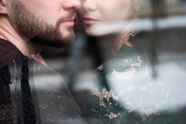 Joven pareja caucásica sentado cerca de ventana y abrazarse mutuamente — Foto de Stock