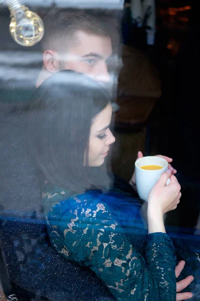 Young caucasian couple sittiing near window, girl holding cup of — Stock Photo, Image