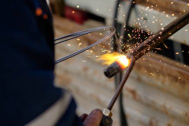 argon gaz metal boru, kaynak için kaynak kullanan adam, elinde kıvılcım uçan her yöne