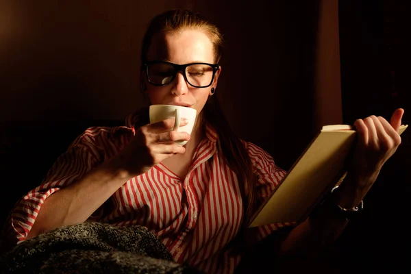 Gember roodharige meisje in ontdaan shirt lezen boek, drinken cof — Stockfoto