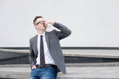 işadamı, gri ceket, mavi kot pantolon, beyaz gömlek giymiş ve