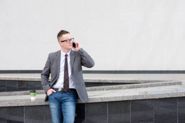 işadamı, gri ceket, mavi kot pantolon, beyaz gömlek giymiş ve