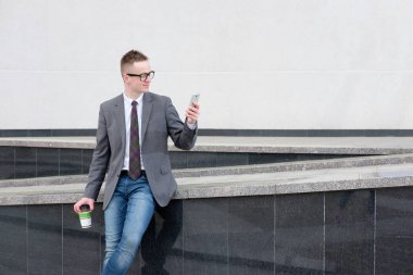 işadamı, gri ceket, mavi kot pantolon, beyaz gömlek giymiş ve