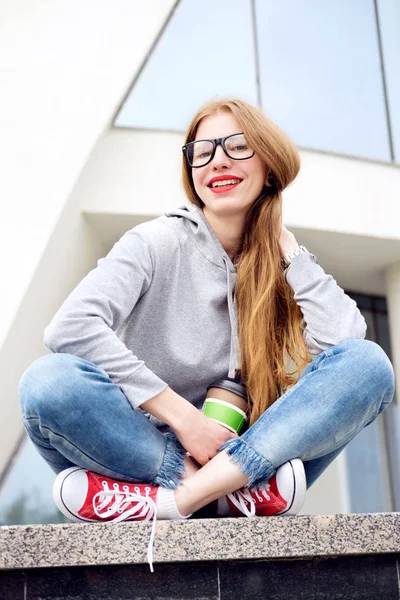 Retrato de chica pelirroja vestida con capucha, jeans, zapatillas rojas a — Foto de Stock