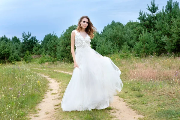 Joven novia bonita en vestido de novia blanco al aire libre, maquillaje y —  Fotos de Stock