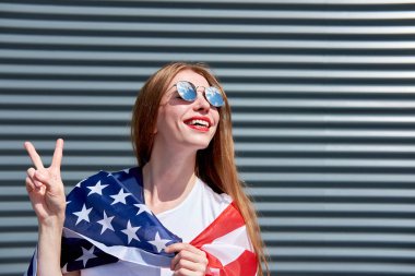 Usa yıldızları ve çizgili bayrak. Neşeli, çekici, kızıl saçlı kız 