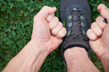 Spor ayakkabısı bağlayan adamın elleri