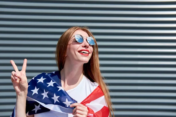 USA stars and stripes flag. Joyful attractive redhead girl with