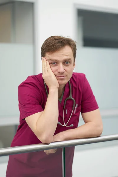 Καυκάσιος Ελκυστικός Κουρασμένος Άντρας Γιατρός Βυσσινί Ιατρική Στολή Ξεκουράζεται Στην — Φωτογραφία Αρχείου