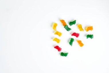 Beyaz arka planda sarı, yeşil, kırmızı ve turuncu çiğneme vitaminleri. Boşluğu kopyala.                             