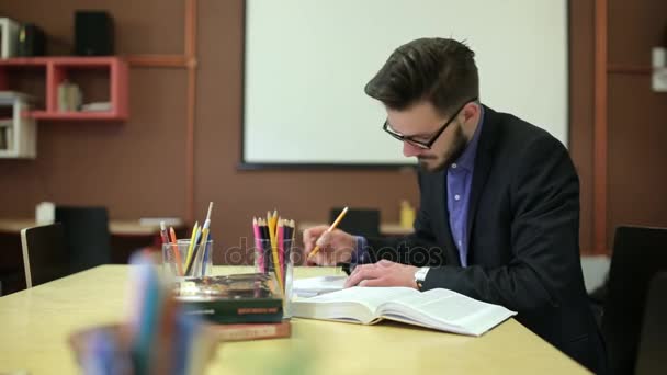 Egy fiatal férfi, tanul, átírja a notebook — Stock videók