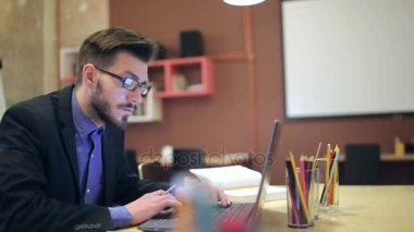 Genç bir adam onun işyeri dizüstü bilgisayar kullanarak