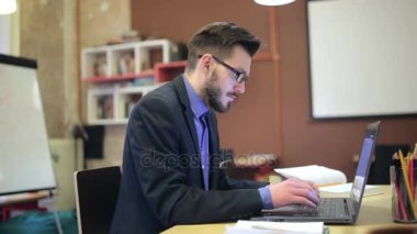 Genç bir adam onun işyeri dizüstü bilgisayar kullanarak