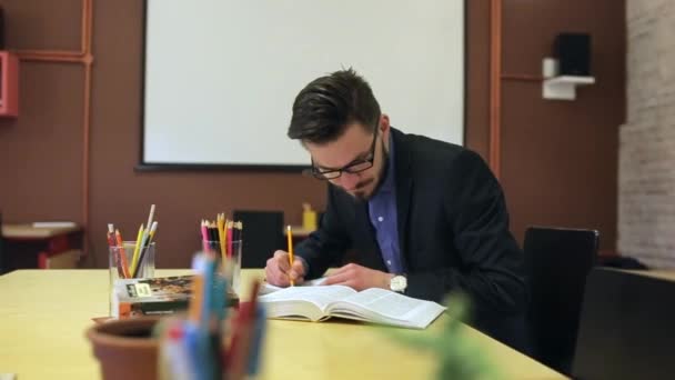 Studying of a young man, rewrites a notebook — Stock Video