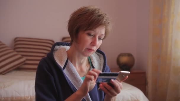 Vrouw online bankieren via smartphone online winkelen met credit card thuis levensstijl — Stockvideo