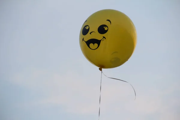 Smilling yellow balloon close up, outdoors