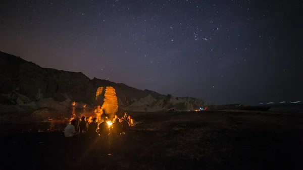 Camp mit Lagerfeuer in der wilden Wüstennacht mit den Sternen Stockbild