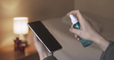 Virüs Bakterilerine Karşı Temizlik Yapan Kadın Cep Telefonunu Dezenfekte Ediyor