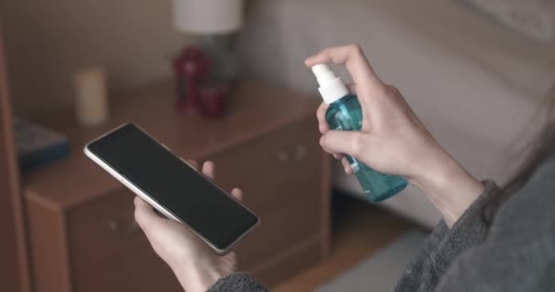 Kobieta czyszcząca dezynfekujący telefon komórkowy przed bakteriami wirusowymi — Wideo stockowe