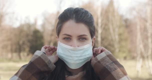 Portret van een jonge student vrouw met een beschermend masker op straat. — Stockvideo