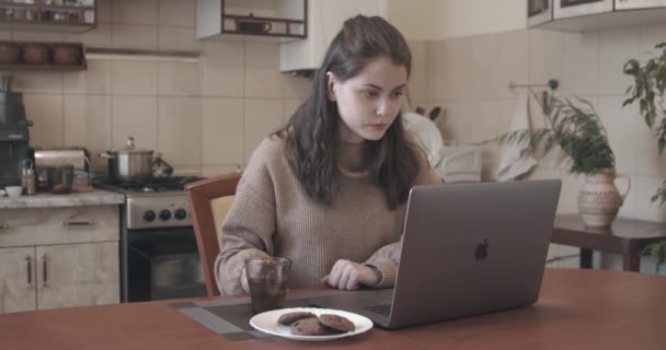 在家里厨房的笔记本电脑上工作的迷人女人 — 图库视频影像