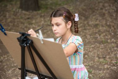 girl painting on easel clipart