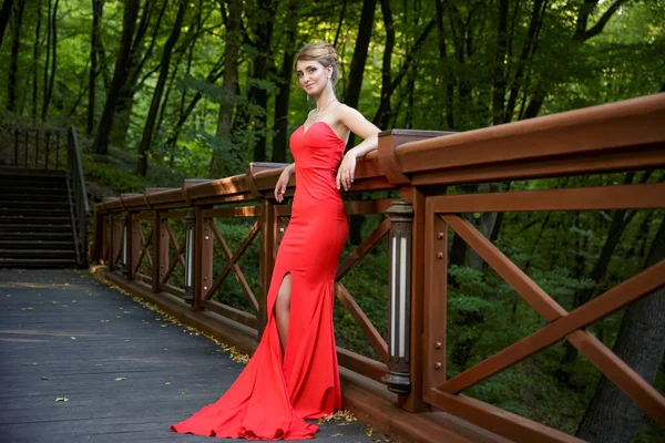 Jovem mulher bonita na ponte de madeira — Fotografia de Stock