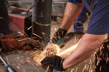 İşçi kesme metal taşlama ile yakın çekim. Demir taşlama sırasında Sparks.