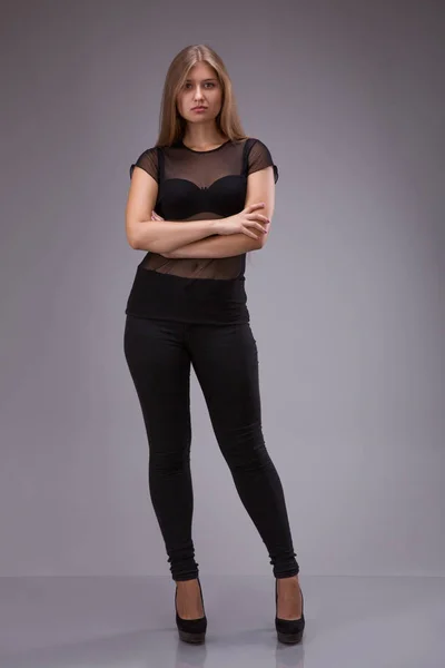 Retrato de um modelo feminino plus size posando em terno preto sobre fundo cinza . — Fotografia de Stock