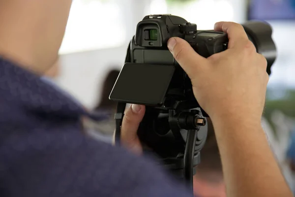 Ruce muže drží fotoaparát profassional a otestujte funkci fotoaparátu. Pohled do černý displej — Stock fotografie