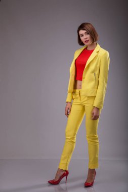 Glamour moda stil katalog rahat kıyafetler tarihi toplantı iş kadını için parti seksi güzel kadın esmer çekim saç giymek sarı kostüm mükemmel vücut şekli modeli takım elbise yürümek