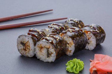 Siyah bir arka plan üzerinde wasabi ve zencefil ile geleneksel Japon rulo