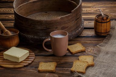 Tereyağı kızarmış ekmek, bal ve süt ahşap backgraund.