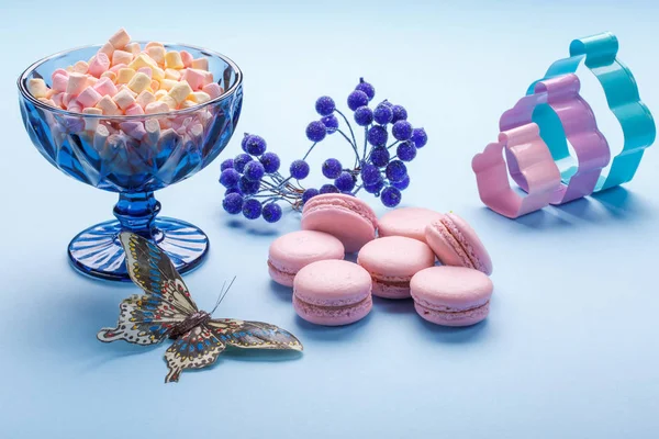 Pasteles de macarrones rosados con coloridos malvaviscos esponjosos en jarrón azul . — Foto de Stock