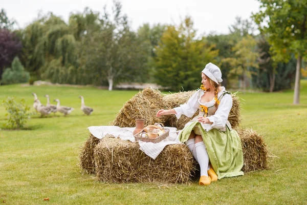 köylü kadın saman üzerinde oturur. Piknik için yürüyüş