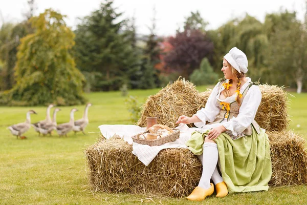 the peasant woman sits on the hay. Hike to a picnic