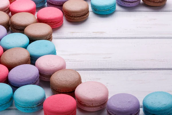 Assortiment de biscuits français colorés macarons sur un fond en bois blanc. Espace pour le texte . — Photo