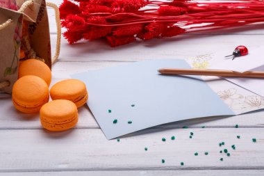 Zanaat kutusu macaroons ile dolu. Fransızca macaroons. Hediye kutusu beyaz ahşap arka plan üzerinde renkli macarons ile düştü.