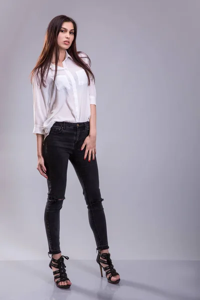 Beautiful sexy young business woman brunette hair wearing white skirt and black pants high heels shoes business clothes for meetings walks summer fall collection