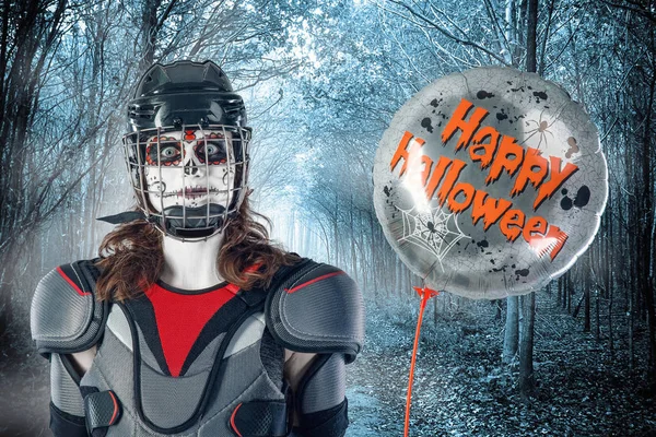 Feliz Halloween. jugador de hockey en un casco de hockey y máscara con un globo contra el telón de fondo o fondo de bosque de miedo. Día de Todos los Santos — Foto de Stock