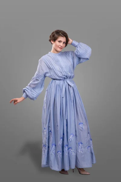 Модель носит длинное синее платье на сером фоне . — стоковое фото