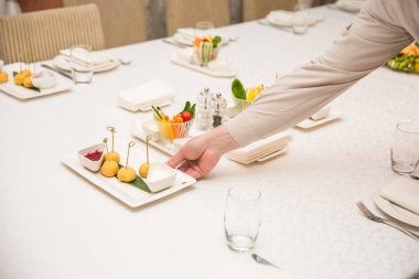 Garsonlardan biri bir restoranda akşam yemeği yer hizmet vermektedir